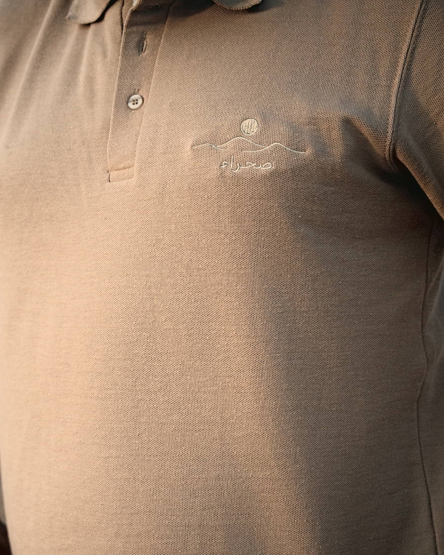 The Sahra Polo, chest at an angle — the embroidered mark and the placket