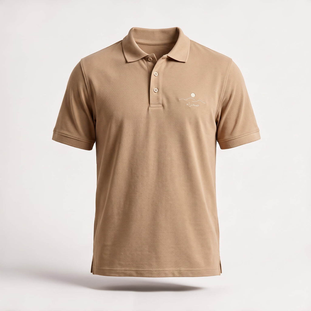 The Sahra Polo in sand, front — 240gsm cotton piqué with a three-button placket and the embroidered صحراء mark on the chest